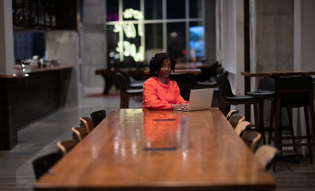 image of a black woman sitting at a conference style table